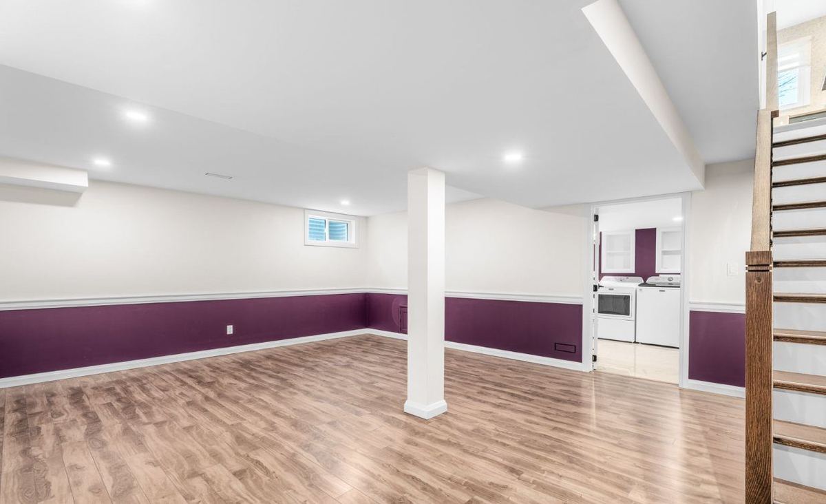 Finished basement with deep purple walls below a white chair rail and light walls above
