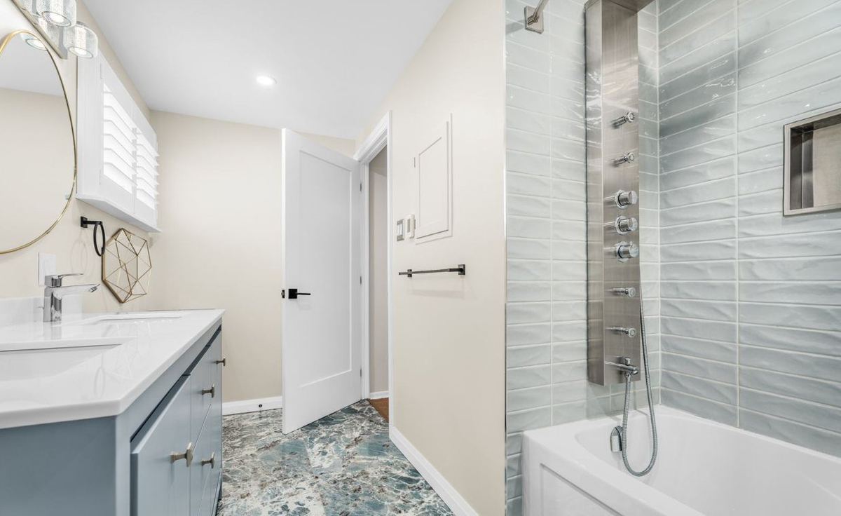 Bathroom with light painted walls, white doors and a tiled tub and shower