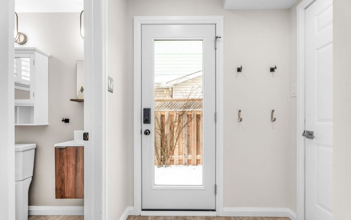 Entryway with light painted walls, white doors and trim, and a glass back door
